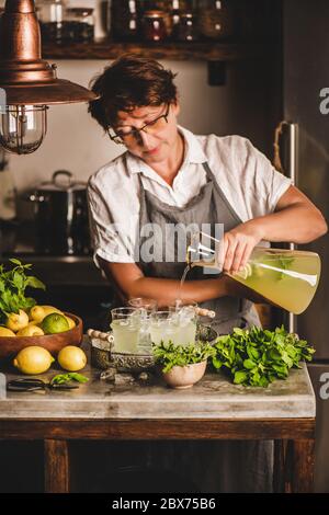 Ältere Frau, die in der Küche frisch hausgemachte Limonade zubereitet Stockfoto