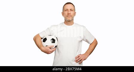 Mann mit Fußball in Akimbo posiert vor weißem Hintergrund Stockfoto