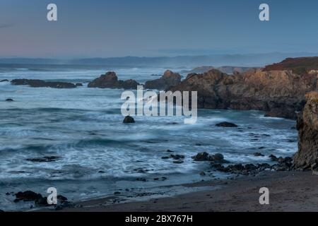 Mendocino, Kalifornien, USA, Fort Bragg, lange Belichtung des Ozeans am Glass Beach an einem wolkenblauen Himmel Abend Stockfoto