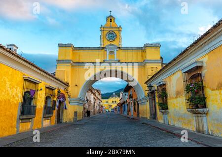 Der Santa Catalina Bogen und die Hauptstraße von Antigua Stadt bei Sonnenaufgang, Guatemala. Stockfoto