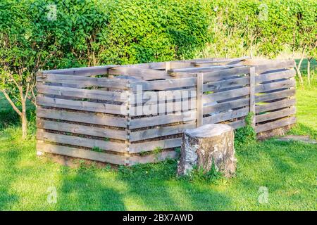 Sehr große dreigliedrige Holzkompostbox, die im schwedischen Garten auf dem Land für die ökologische Kompostierung von Lebensmitteln und Gartenabfällen, organisch, steht Stockfoto