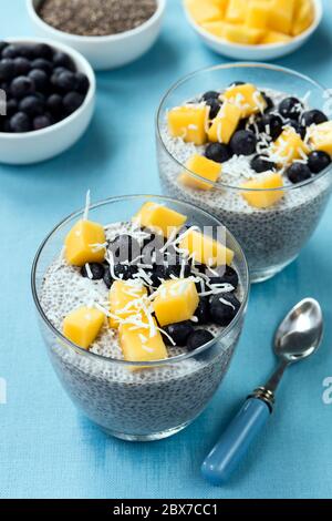 Chia-Samenpudding, mit Heidelbeeren, Mango und Kokosnuss. Veganes Superfood mit Mandelmilch. Stockfoto