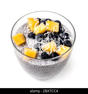 Chia Pudding isoliert in Glas mit Heidelbeeren, Mango und Kokosraspeln. Veganes Superfood. Stockfoto
