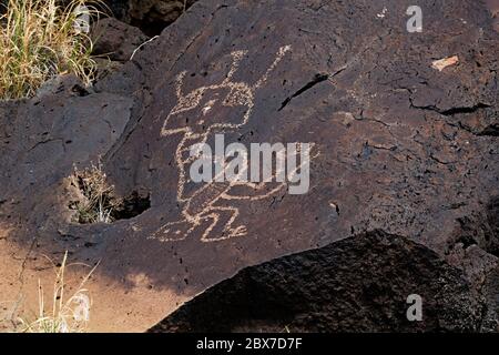 NM00525-00...NEW MEXICO - EINE mystische Figur, die in den Wüstenlack auf einem basaltischen Felsen im Petroglyph National Monument gepickt wurde. Stockfoto