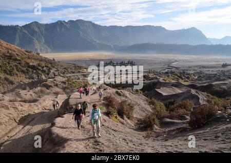 Touristen, die auf den Gipfel des Mount Bromo Vulkan zu Fuß, um den Krater, eine der am meisten besuchten Sehenswürdigkeiten in Ost-Java, Indonesien zu sehen. Stockfoto