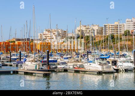 Viele Motorboote und Yachten liegen an einem sonnigen Tag mit blauem Himmel an der Marina in Portimao, der westlichen Algarve, Südportugal Stockfoto