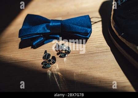 Nahaufnahme von Manschettenknöpfen aus Gesen auf Holzhintergrund. Manschettenknöpfe in Schiffspropellerform. Konzept für Hochzeitstag. Stockfoto