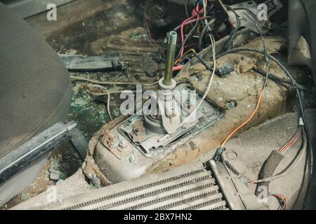 Innenansicht des zerlegten Getriebes eines gebrochenen in Crash-Innenraum des verlassenen alten Autos bei Schrott Stockfoto