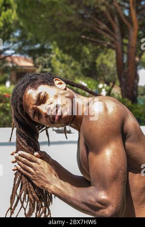 Junger muskulöser schwarzer Mann mit langen Dreadlocks. Hochwertige Fotos Stockfoto