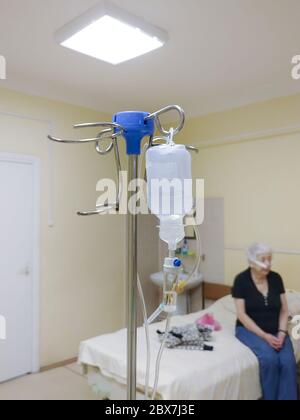 Sankt-Petersburg, Russland, februar 2020: Dropper in der Krankenstation vor dem Hintergrund des Bettes und ältere Frau Patientin Stockfoto