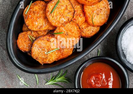 Süßkartoffel Pommes Frites mit Ketchup und Rosmarin. Stockfoto