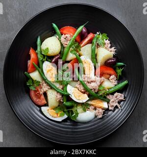 Salat-Nicoise. Thunfisch mit Kartoffeln, Eiern, Bohnen, Tomaten, Oliven und Petersilie. Stockfoto