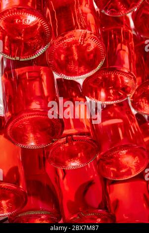 Getränke in Flaschen abgefüllt und stapelt gelagert. Flaschen roter Getränke auf einem speziellen Regal. Alkohol, alkoholfreie Getränke in 0.5 Liter Flaschen. Blick von unten Stockfoto