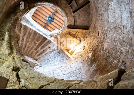 Alte Treppe aus Schnecke aus Stein gebaut, beleuchtet durch das Licht der Sonne. Priego de cordoba, Andalusien. Spanien Stockfoto