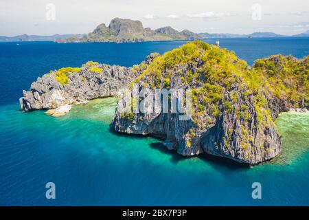 Blick von oben, Luftaufnahme der unbekannten Insel, umgeben von türkisfarbenem, kristallklarem Meer. Bacuit Bay, El Nido, Palawan, Philippinen Stockfoto