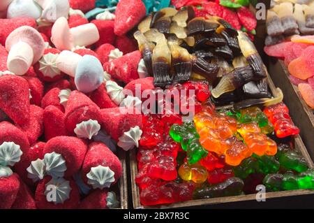 Verschiedene Gelee-Bohnen mit verschiedenen Formen wie bunte Bären, Erdbeeren, Pilze auf einem Messestand Stockfoto