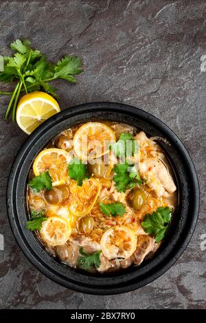 Hähnchenauflauf mit Zitrone, Oliven und Koriander. In traditionellem Tagine gekocht. Stockfoto