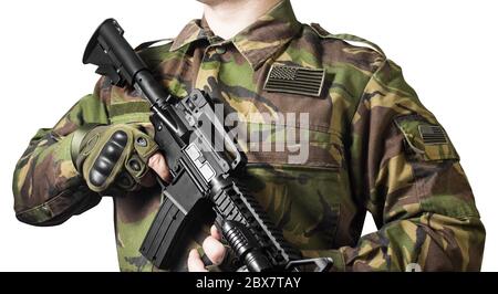 Isoliertes Nahaufnahme-Foto einer männlichen Brust, die in Militärjacke mit automatischem Gewehr und amerikanischem Flaggenabzeichen steht. Stockfoto