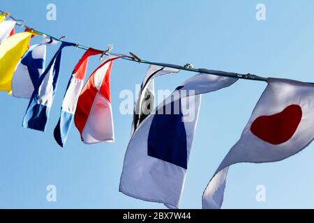 Foto einer verschiedenen Landfahnen weben auf Wind und blauer Himmel auf einem Hintergrund. Stockfoto