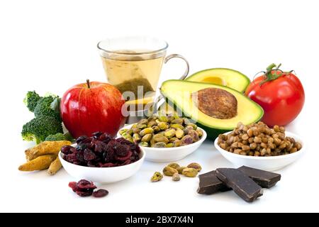 Vielfalt der Lebensmittel, die reich an Antioxidantien, isoliert auf weiß. Enthält Brokkoli, Apfel, grüner Tee, Pistazien, Preiselbeeren, Avocado, Tomaten, Linsen und Stockfoto