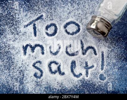 'Zu viel Salz!' In Salz, mit Shaker geschrieben. Warnung im Zusammenhang mit Diabetes, Bluthochdruck, etc. Stockfoto