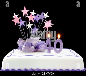 Torte mit Kerzen Nummer 40. Mit Bändern und Sternformen dekoriert, in Pastelltönen auf schwarzem Hintergrund. Stockfoto