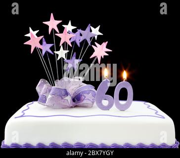Torte mit Kerzen Nummer 60. Mit Bändern und Sternformen dekoriert, in Pastelltönen auf schwarzem Hintergrund. Stockfoto