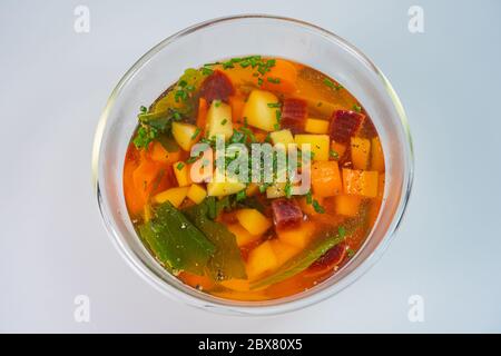 Hausgemachte Gemüsesuppe in Glasschüssel auf weißem Hintergrund Stockfoto