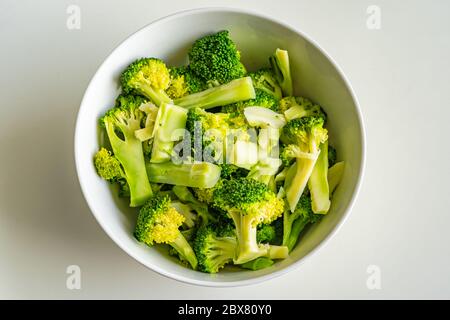 Schüssel mit gekochtem Brokkoli auf weißem Hintergrund isoliert Stockfoto