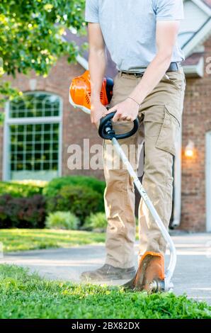 Kaukasischer Mann mit Unkrautesser / Linie Trimmer in Kentucky Stockfoto