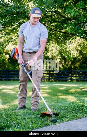 Kaukasischer Mann mit Unkrautesser / Linie Trimmer in Kentucky Stockfoto