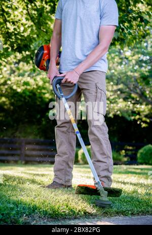 Kaukasischer Mann mit Unkrautesser / Linie Trimmer in Kentucky Stockfoto