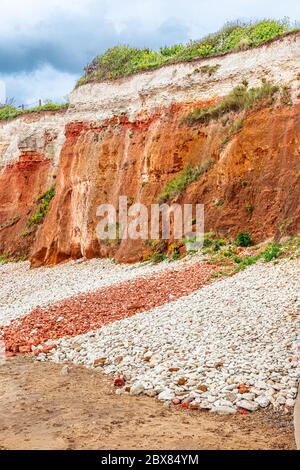 Orangene, rote und weiße Sedimentgesteine am Strand in Hunstanton, Norfolk, East Anglia, Großbritannien. Stockfoto