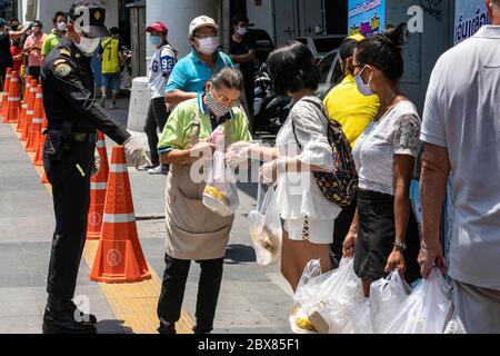 Freiwillige geben während der Covid-Pandemie in Bangkok, Thailand, an arme Menschen in der Foodbank kostenlose Nahrung Stockfoto