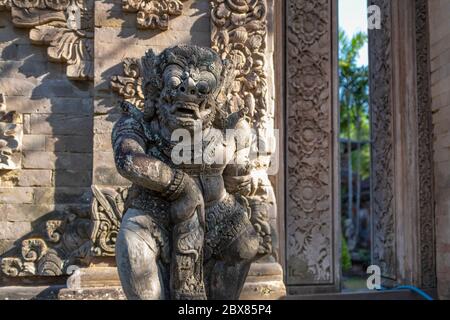 Traditionelle Wache Dämon Statue in hellgrauem Stein geschnitzt, ohne Menschen, Denpasar, Bali, Indonesien Stockfoto