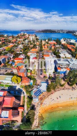 Toller Sandstrand in Manly Vorort von Sydney an der Pazifikküste - vertikales Luftpanorama mit Blick auf den entfernten Hafen von Sydney und das Stadtzentrum. Stockfoto