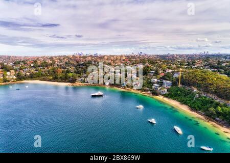Mid Harbour in Sydney - Luftaufnahme über schwimmende Yachten und kleinen Sandstrand in Richtung Innenstadt CBD und Lower North Shore Wohnvororte. Stockfoto