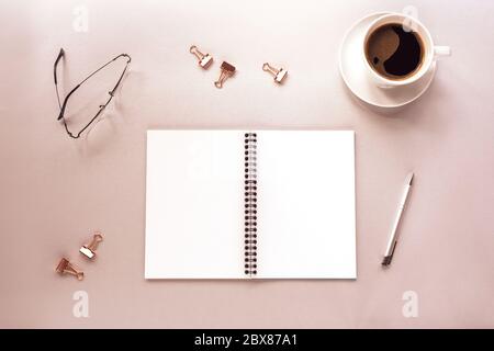 Tasse Kaffee und blank Spiral Notizblock Mockup auf grauem Hintergrund mit Stift und Brille. Konzept „Work from Home“. Draufsicht, flach liegend Stockfoto