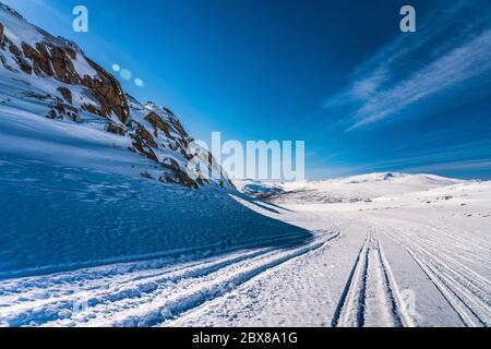 Seitenansicht am Ende des Atoklinten-Gebirges in Lappland, Nordschweden. Alle Schneemobile fahren hier, viele Wanderwege um. Die Sonne scheint direkt über dem Hotel Stockfoto