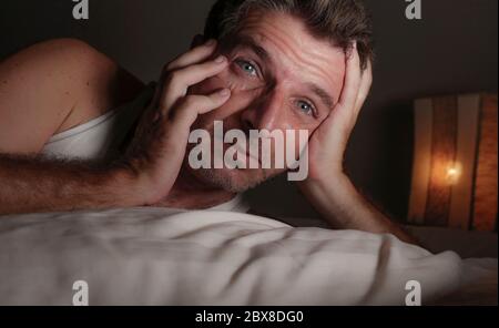 Nahaufnahme Gesicht Porträt von schlaflos und wach attraktiven Mann mit weit geöffneten Augen in der Nacht auf dem Bett liegend leiden Schlaflosigkeit Schlafstörung versuchen zu versuchen Stockfoto