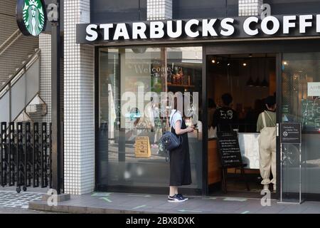 Starbucks Café in Urayasu City während des Coronavirus Ausbruchs. Es gelten Regeln für soziale Distanzen, sodass Kunden sich auf Pfeile außerhalb aufstellen müssen. Stockfoto