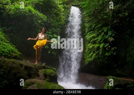 Im Freien tropischen Lifestyle Porträt von jungen attraktiven und glücklich Hipster Mädchen genießen Natur aufgeregt Gefühl frei bei erstaunlich schönen Wasserfall in Stockfoto