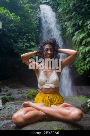 Im Freien tropischen Lifestyle Porträt von jungen attraktiven und glücklich Hipster Mädchen genießen Natur aufgeregt Gefühl frei bei erstaunlich schönen Wasserfall in Stockfoto