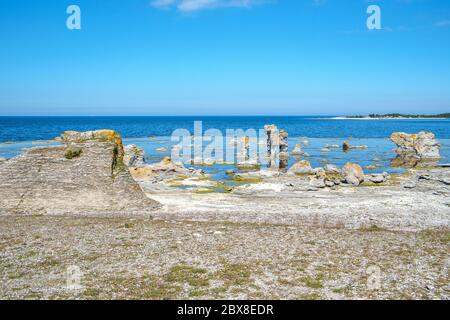 Gamla Hamn auf der Insel Fårö in Schweden. Die Insel Fårö in der Ostsee ist berühmt für ihre einzigartigen Kalksteinfelsen, die von den Einheimischen als „raukar“ bezeichnet werden Stockfoto