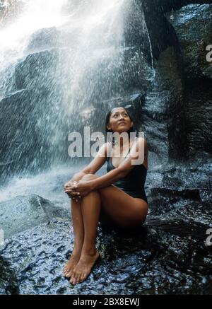 Junge attraktive und glückselige asiatische indonesische Frau überwältigt von der Schönheit der natürlichen Wasserfall im tropischen Dschungel genießen glücklich die erstaunliche und Stockfoto