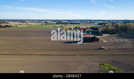 Luftaufnahme eines Traktors, der Weizen auf dem landwirtschaftlichen Feld sät Stockfoto