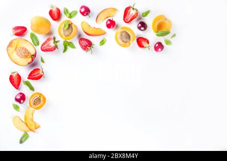 Sommer Hintergrund mit frischen Früchten und Beeren auf weißem Hintergrund. Set aus verschiedenen saisonalen Früchten und Beeren - Erdbeere, Aprikosen, Pfirsichscheiben, Lch Stockfoto