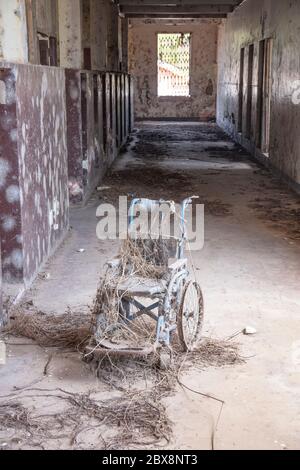 Rollstuhl im Korridor eines verlassenen Krankenhauses oder einer Schule Stockfoto