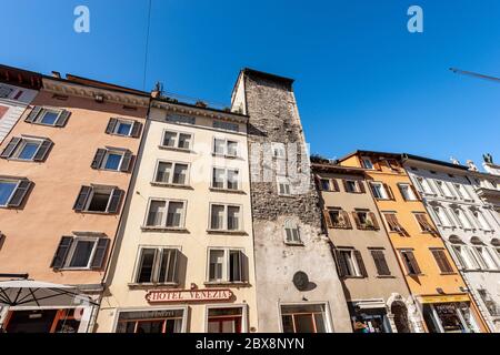 Alte Häuser und ein antiker Turm in der Innenstadt von Trient (Via Rodolfo Belenzani), der Hauptstraße der Stadt. Trentino-Südtirol, Italien, Europa. Stockfoto