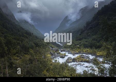 Dramatische Moody Blick auf den Fluss vom Buerbreen Gletscher im Tal, Odda, Norwegen Stockfoto
